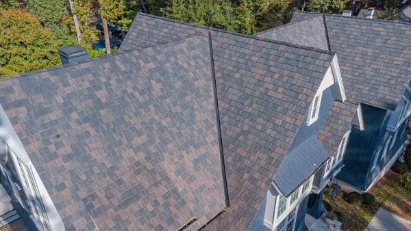 This realistic composite cedar roof in the Black Oak color beautifully contrasts the white trim on the home. 
